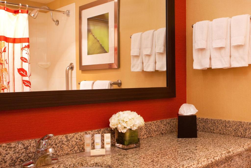 Guest bathroom vanity with granite counter, framed mirror and folded towels