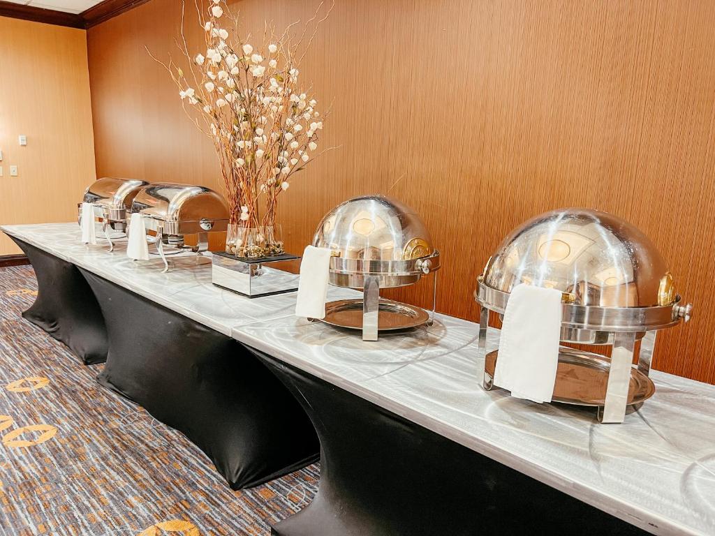 Breakfast buffet laid out with covered chafing dishes on a marble counter